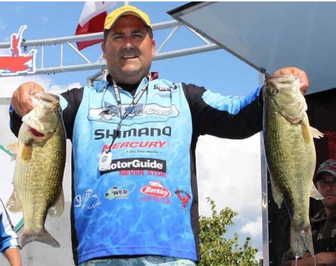 Tournament weigh-in with angler holding bass